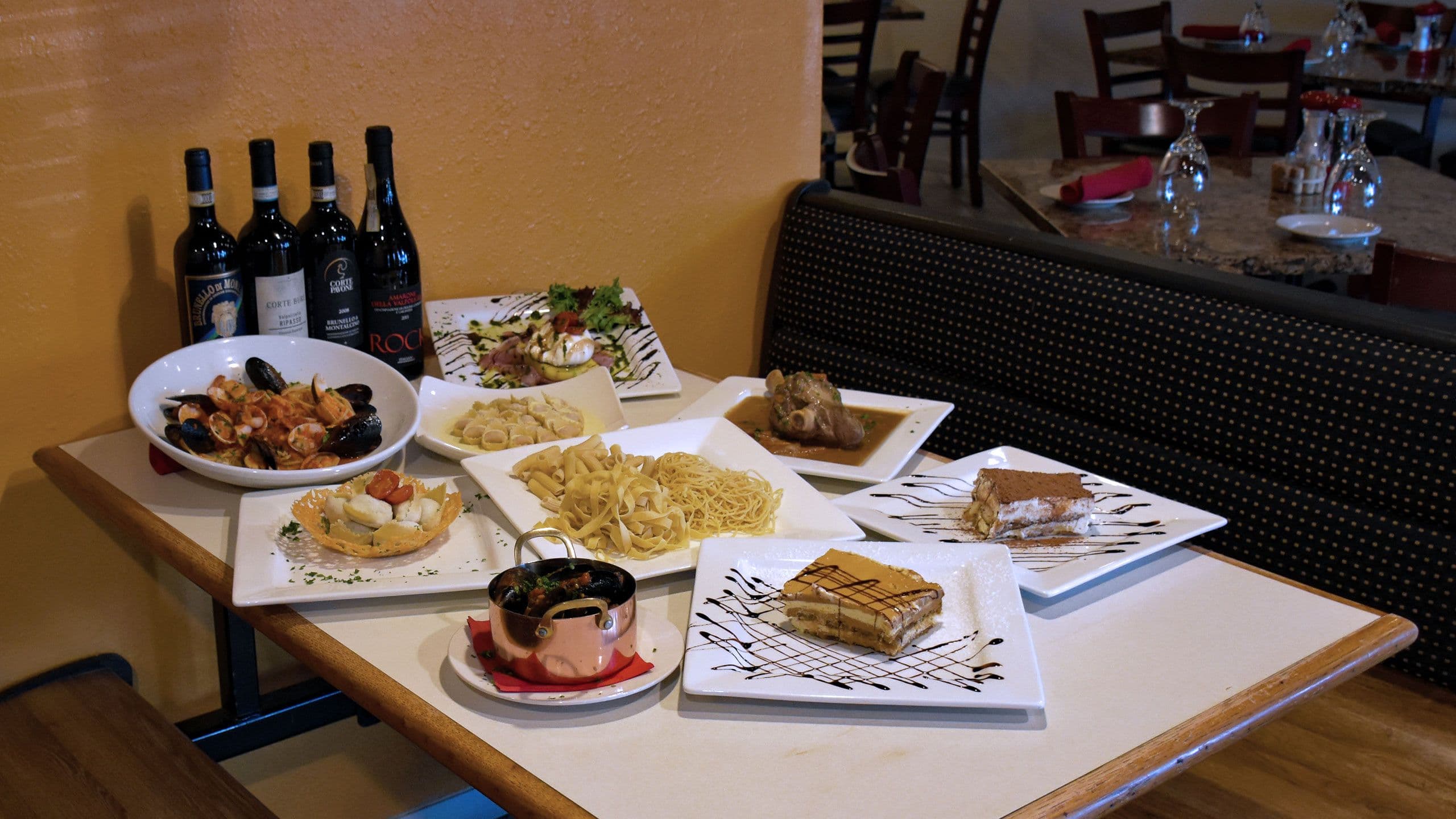 A table set with Tiramisu Ristorante Italiano's handmade pastas, wine and tiramisu